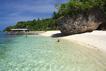 huge rock on white sand beach at the eastern shore of Higatangan Island, Biliran