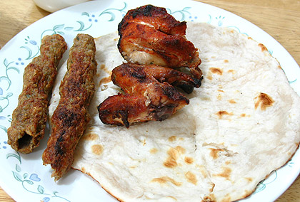seekh kebabs, chicken boti and naan bread on a plate