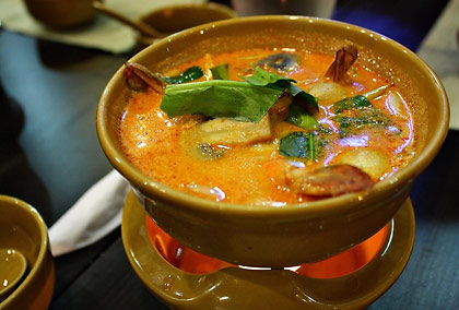 bowl of tom yam kung soup over a warmer